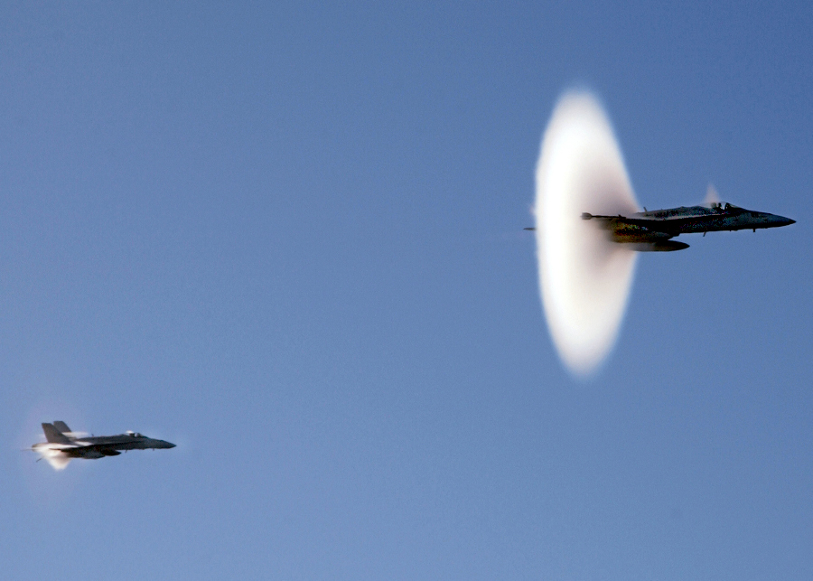 1. United States Fighter Jet From the 'Black Knights' of the Marine Fighter Attack Squadron Three One Four (VMFA-314). January 29, 2004, Pacific Ocean. Reaching the sound barrier, breaking the sound barrier: Flying at transonic speeds (flying transonically) -- speeds varying near and at the speed of sound (supersonic) -- can generate impressive condensation clouds caused by the Prandtl-Glauert Singularity. For a scientific explanation, see Professor M. S. Cramer's Gallery of Fluid Mechanics, Prandtl-Glauert Singularity at <http://www.GalleryOfFluidMechanics.com/conden/pg_sing.htm>; and Foundations of Fluid Mechanics, Navier-Stokes Equations Potential Flows: Prandtl-Glauert Similarity Laws at <http://www.Navier-Stokes.net/nspfsim.htm>. Photo Credit: Photographer's Mate Airman Chris M. Valdez, Navy NewsStand - Eye on the Fleet Photo Gallery (http://www.news.navy.mil/view_photos.asp, 040129-N-0905V-024), United States Navy (USN, http://www.navy.mil), United States Department of Defense (DoD, http://www.DefenseLink.mil or http://www.dod.gov), Government of the United States of America (USA).