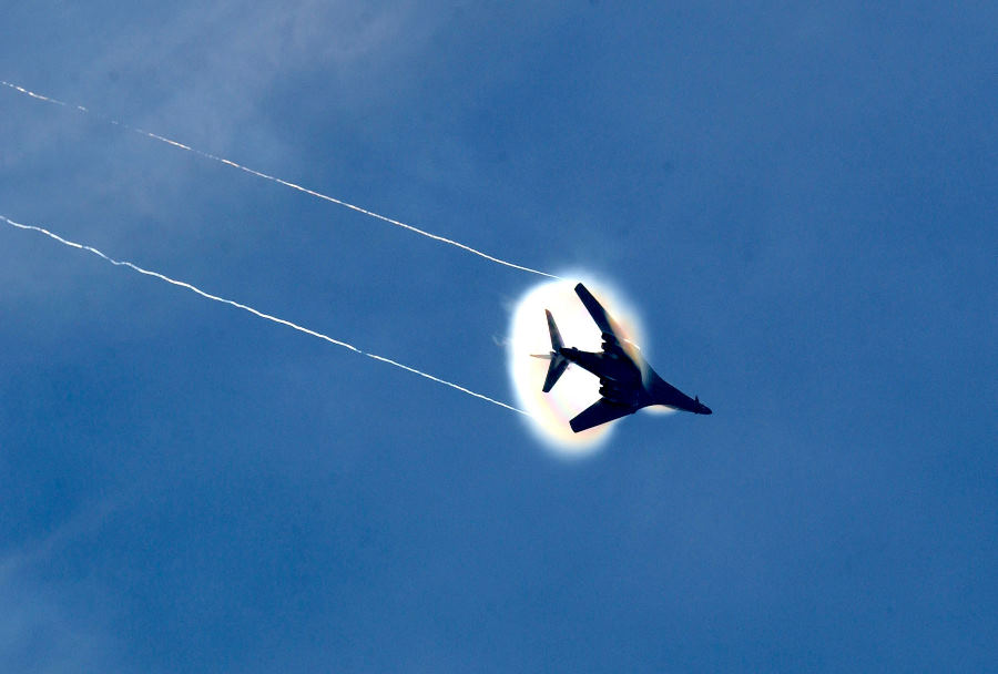 2. A B-1B Lancer Bomber Banks Left, United States Air Force. January 16, 2004, Southwest Asia. Flying at transonic speeds -- speeds varying near and at the speed of sound (supersonic) -- can generate impressive condensation clouds caused by the Prandtl-Glauert Singularity. For a scientific explanation, see Professor M. S. Cramer's Gallery of Fluid Mechanics, Prandtl-Glauert Singularity at <http://www.GalleryOfFluidMechanics.com/conden/pg_sing.htm>; and Foundations of Fluid Mechanics, Navier-Stokes Equations Potential Flows: Prandtl-Glauert Similarity Laws at <http://www.Navier-Stokes.net/nspfsim.htm>. Photo Credit: Staff Sgt. Shelley Gill, Still Photography Journeyman, 125th Fighter Wing, Florida Air National Guard, USA; Air Force Link - Photos (http://www.af.mil/photos, 040116-F-0971G-156, Breaking the barrier), United States Air Force (USAF, http://www.af.mil), United States Department of Defense (DoD, http://www.DefenseLink.mil or http://www.dod.gov), Government of the United States of America (USA). Additional information: The USAF B1-B Lancer photos leading to this one are in the ChamorroBible.org 3rd Collection of Prandtl-Glauert Condensation Clouds, a photo sequence presented on Umayanggan (Disiembre) 16, 2004. On the same day, January 16th, 2004, Staff Sgt. Shelley R. Gill photographed the same B1-B aircraft with a different Prandtl-Glauert condensation cloud. These photos are in the ChamorroBible.org 4th Collection of Prandtl-Glauert Condensation Clouds published on Umayanggan (Disiembre) 17, 2004.