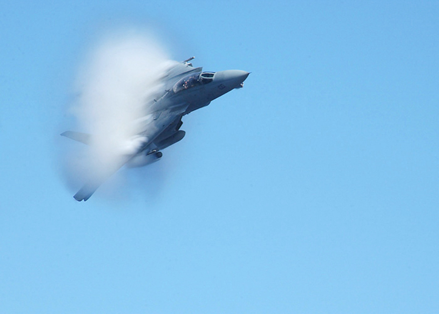 3. United States Navy F-14B Tomcat Fighter Jet. April 26, 2002, Mediterranean Sea. Flying at transonic speeds -- speeds varying near and at the speed of sound (supersonic) -- can generate impressive condensation clouds caused by the Prandtl-Glauert Singularity. For a scientific explanation, see Professor M. S. Cramer's Gallery of Fluid Mechanics, Prandtl-Glauert Singularity at <http://www.GalleryOfFluidMechanics.com/conden/pg_sing.htm>; and Foundations of Fluid Mechanics, Navier-Stokes Equations Potential Flows: Prandtl-Glauert Similarity Laws at <http://www.Navier-Stokes.net/nspfsim.htm>. Photo Credit: Photographer's Mate 3rd Class Ramon Preciado, Navy NewsStand - Eye on the Fleet Photo Gallery (http://www.news.navy.mil/view_photos.asp, 020426-N-8029P-001), United States Navy (USN, http://www.navy.mil), United States Department of Defense (DoD, http://www.DefenseLink.mil or http://www.dod.gov), Government of the United States of America (USA).