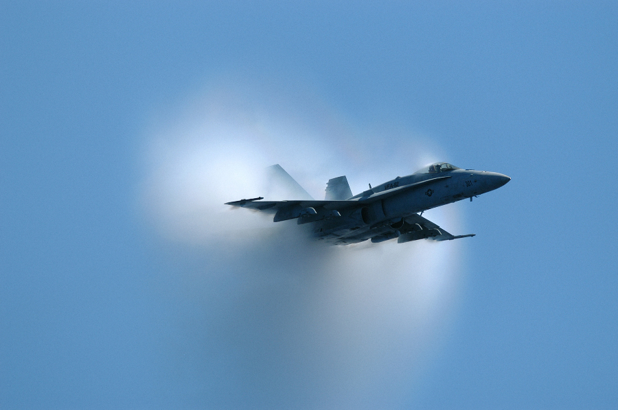 4. An F/A-18 Hornet Fighter Jet, June 9, 2004. United States Navy, Atlantic Ocean. Reaching the sound barrier, breaking the sound barrier: Flying at transonic speeds (flying transonically) -- speeds varying near and at the speed of sound (supersonic) -- can generate impressive condensation clouds caused by the Prandtl-Glauert Singularity. For a scientific explanation, see Professor M. S. Cramer's Gallery of Fluid Mechanics, Prandtl-Glauert Singularity at <http://www.GalleryOfFluidMechanics.com/conden/pg_sing.htm>; and Foundations of Fluid Mechanics, Navier-Stokes Equations Potential Flows: Prandtl-Glauert Similarity Laws at <http://www.Navier-Stokes.net/nspfsim.htm>. Photo Credit: Photographer's Mate 3rd Class Milosz Reterski, Navy NewsStand - Eye on the Fleet Photo Gallery (http://www.news.navy.mil/view_photos.asp, 040609-N-9742R-041), United States Navy (USN, http://www.navy.mil), United States Department of Defense (DoD, http://www.DefenseLink.mil or http://www.dod.gov), Government of the United States of America (USA).