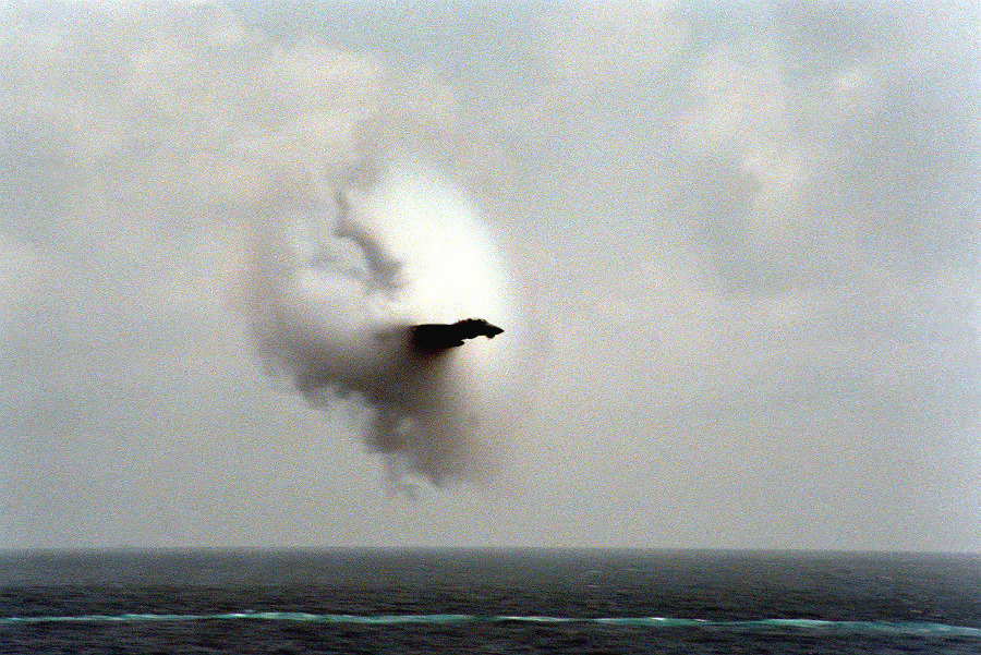 5. An F-14A Tomcat Fighter Jet, January 31, 1987, United States Navy. Reaching the sound barrier, breaking the sound barrier: Flying at transonic speeds (flying transonically) -- speeds varying near and at the speed of sound (supersonic) -- can generate impressive condensation clouds caused by the Prandtl-Glauert Singularity. For a scientific explanation, see Professor M. S. Cramer's Gallery of Fluid Mechanics, Prandtl-Glauert Singularity at <http://www.GalleryOfFluidMechanics.com/conden/pg_sing.htm>; and Foundations of Fluid Mechanics, Navier-Stokes Equations Potential Flows: Prandtl-Glauert Similarity Laws at <http://www.Navier-Stokes.net/nspfsim.htm>. Photo Credit: Photographer's Mate 2nd Class Johnson, Defense Visual Information Center (DVIC, http://www.DoDMedia.osd.mil, DNSC8711321) and United States Navy (USN, http://www.navy.mil), United States Department of Defense (DoD, http://www.DefenseLink.mil or http://www.dod.gov), Government of the United States of America (USA).