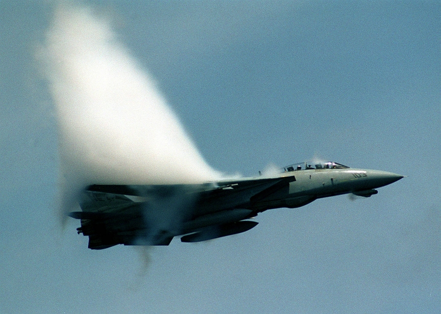 10. An F-14D 'Super Tomcat' Fighter Jet With the Fighter Squadron Two (VF-2), July 10, 1999, USS Constellation (CV 64), United States Navy. Reaching the sound barrier, breaking the sound barrier: Flying at transonic speeds (flying transonically) -- speeds varying near and at the speed of sound (supersonic) -- can generate impressive condensation clouds caused by the Prandtl-Glauert Singularity. For a scientific explanation, see Professor M. S. Cramer's Gallery of Fluid Mechanics, Prandtl-Glauert Singularity at <http://www.GalleryOfFluidMechanics.com/conden/pg_sing.htm>; and Foundations of Fluid Mechanics, Navier-Stokes Equations Potential Flows: Prandtl-Glauert Similarity Laws at <http://www.Navier-Stokes.net/nspfsim.htm>. Photo Credit: Ensign John Gay, Image ID: 990710-N-6483G-001, Expeditionary Warfare Division (N75) in the Office of the Chief of Naval Operations, United States Navy (USN, http://www.navy.mil), United States Department of Defense (DoD, http://www.DefenseLink.mil or http://www.dod.gov), Government of the United States of America (USA).