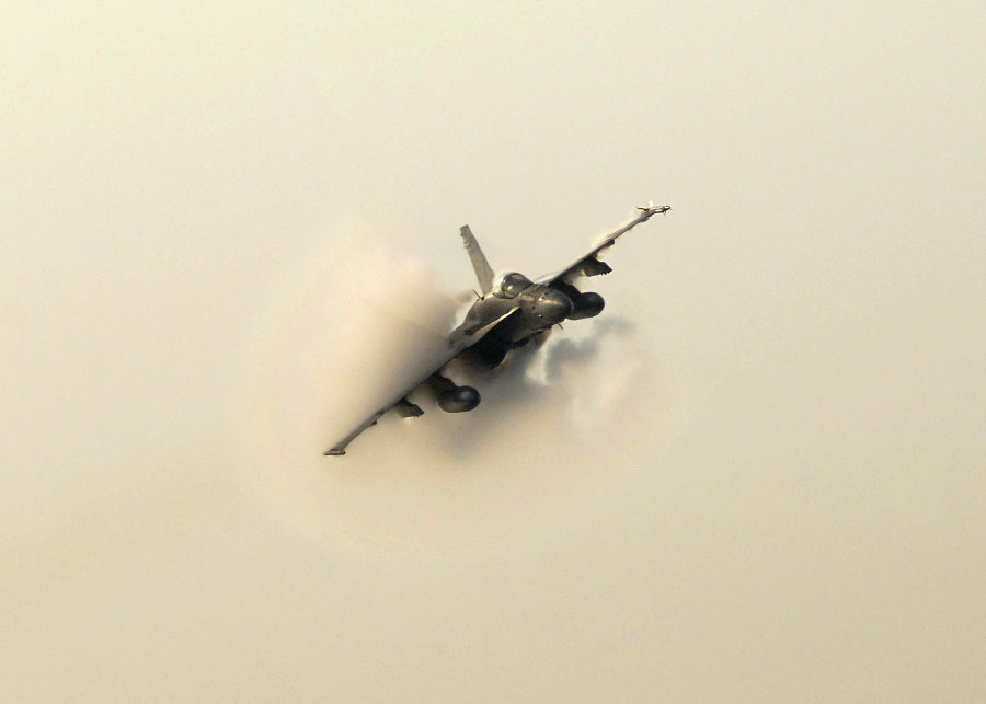 4. An F/A-18 Hornet Fighter Jet, June 9, 2004. United States Navy, Atlantic Ocean. Reaching the sound barrier, breaking the sound barrier: Flying at transonic speeds (flying transonically) -- speeds varying near and at the speed of sound (supersonic) -- can generate impressive condensation clouds caused by the Prandtl-Glauert Singularity. For a scientific explanation, see Professor M. S. Cramer's Gallery of Fluid Mechanics, Prandtl-Glauert Singularity at <http://www.GalleryOfFluidMechanics.com/conden/pg_sing.htm>; and Foundations of Fluid Mechanics, Navier-Stokes Equations Potential Flows: Prandtl-Glauert Similarity Laws at <http://www.Navier-Stokes.net/nspfsim.htm>. Photo Credit: Photographer's Mate 3rd Class Milosz Reterski, Navy NewsStand - Eye on the Fleet Photo Gallery (http://www.news.navy.mil/view_photos.asp, 040609-N-9742R-041), United States Navy (USN, http://www.navy.mil), United States Department of Defense (DoD, http://www.DefenseLink.mil or http://www.dod.gov), Government of the United States of America (USA).