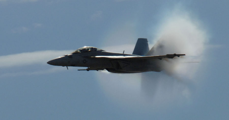 4. An F/A-18F Super Hornet Fighter Jet Assigned to the 'Screaming Eagles' of Strike Fighter Squadron One Two Two (VFA-122), Miramar Air Show, October 13, 2006, Marine Corps Air Station Miramar, San Diego, State of California, USA. Flying at transonic speeds (flying transonically) -- speeds varying near and at the speed of sound (supersonic) -- can generate impressive condensation clouds caused by the Prandtl-Glauert Singularity. For a scientific explanation, see Professor M. S. Cramer's Gallery of Fluid Mechanics, Prandtl-Glauert Singularity at <http://www.GalleryOfFluidMechanics.com/conden/pg_sing.htm>; and Foundations of Fluid Mechanics, Navier-Stokes Equations Potential Flows: Prandtl-Glauert Similarity Laws at <http://www.Navier-Stokes.net/nspfsim.htm>. Photo Credit: Mass Communication Specialist 2nd Class Scott Taylor, Navy NewsStand - Eye on the Fleet Photo Gallery (http://www.news.navy.mil/view_photos.asp, 061013-N-9500T-008), United States Navy (USN, http://www.navy.mil), United States Department of Defense (DoD, http://www.DefenseLink.mil or http://www.dod.gov), Government of the United States of America (USA).