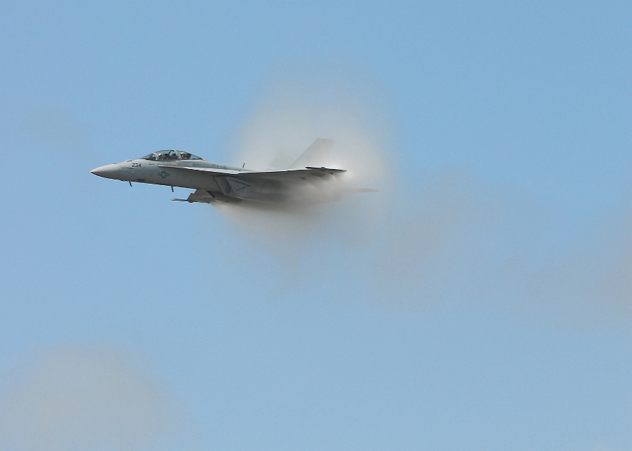 11. A Transonic F/A-18F Super Hornet Fighter Jet Assigned to the 'Checkmates' of Strike Fighter Squadron Two One One (VFA-211), 2007 Naval Air Station Oceana Air Show, Naval Air Station Oceana, September 9, 2007, Virginia Beach, Commonwealth of Virginia, USA. Flying at transonic speeds (flying transonically) -- speeds varying near and at the speed of sound (supersonic) -- can generate impressive condensation clouds caused by the Prandtl-Glauert Singularity. For a scientific explanation, see Professor M. S. Cramer's Gallery of Fluid Mechanics, Prandtl-Glauert Singularity at <http://www.GalleryOfFluidMechanics.com/conden/pg_sing.htm>; and Foundations of Fluid Mechanics, Navier-Stokes Equations Potential Flows: Prandtl-Glauert Similarity Laws at <http://www.Navier-Stokes.net/nspfsim.htm>. Photo Credit: Mass Communication Specialist Seaman Joshua Nuzzo, United States Navy (USN, http://www.navy.mil); Defense Visual Information Center (DVIC, http://www.DoDMedia.osd.mil, 070909-N-4515N-438) and United States Navy (USN, http://www.navy.mil), United States Department of Defense (DoD, http://www.DefenseLink.mil or http://www.dod.gov), Government of the United States of America (USA).